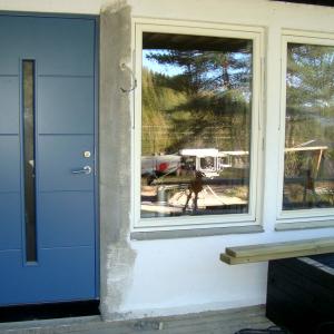 Ny blå ytterdør og nye hvite vinduer sett fra utsiden.